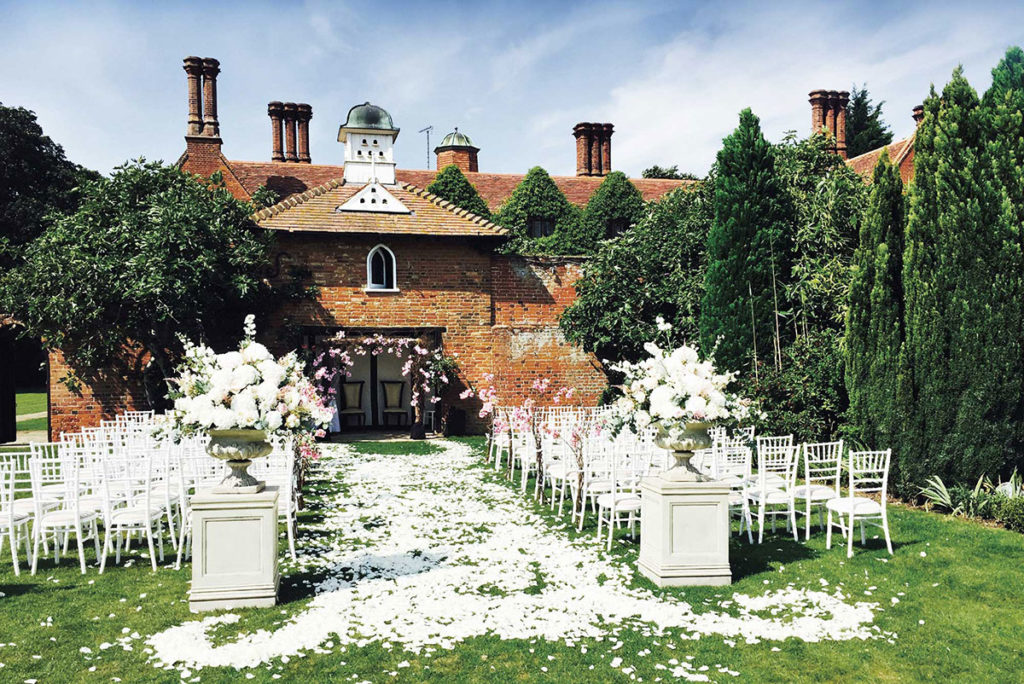 Image of Woodhall Manor outside of the venue showing an outdoor ceremony.