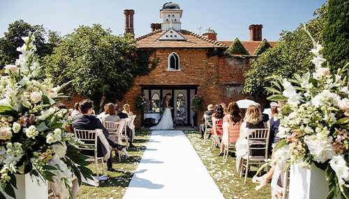 Outdoor ceremony under the dovecote at Woodhall manor