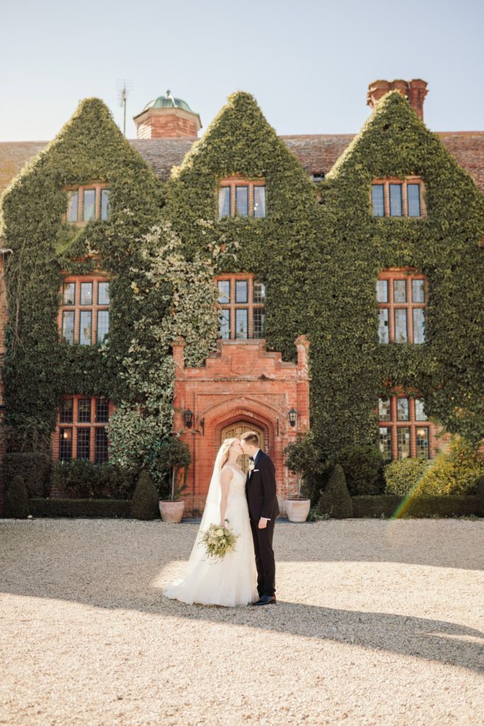 bride & groom front of manor